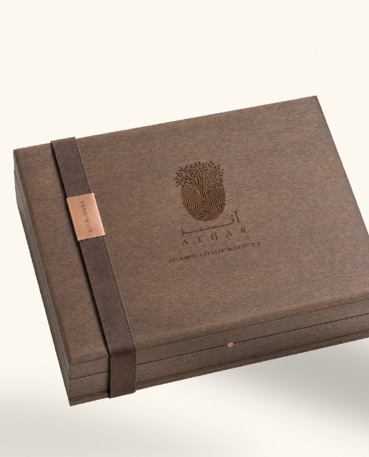 The ATHAR Legacy box in dark walnut, the mark engraved on the lid and a copper ID plate on a leather strap