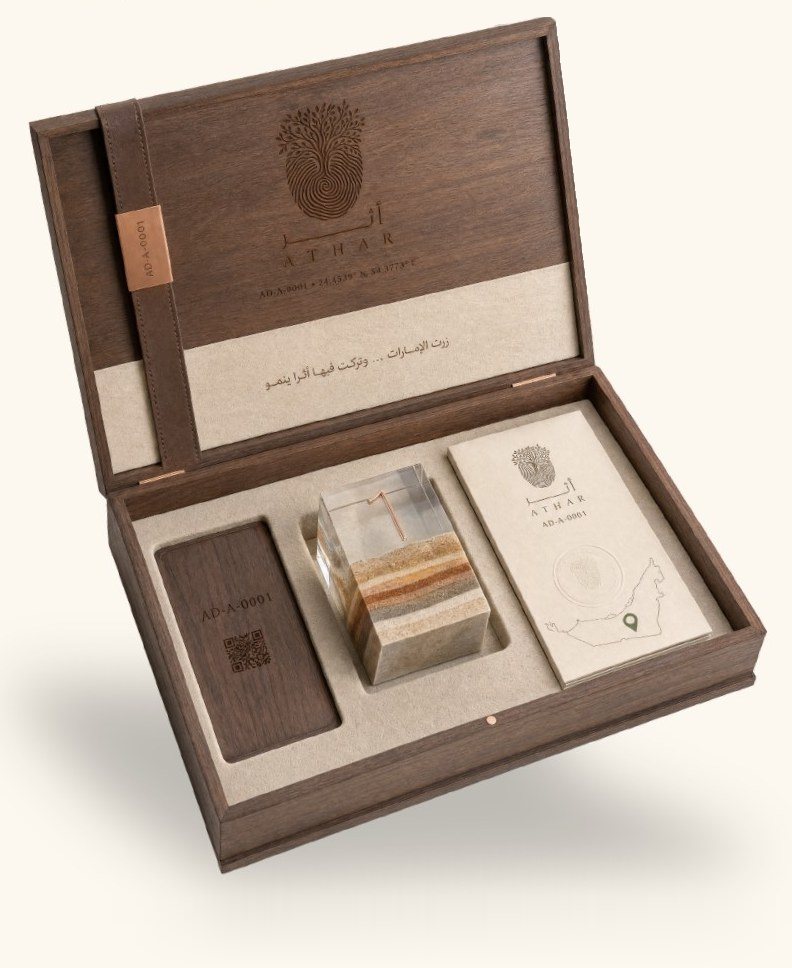 The ATHAR Legacy box open: a walnut tag with the tree’s ID, a keepsake of layered sand and a certificate card with a map
